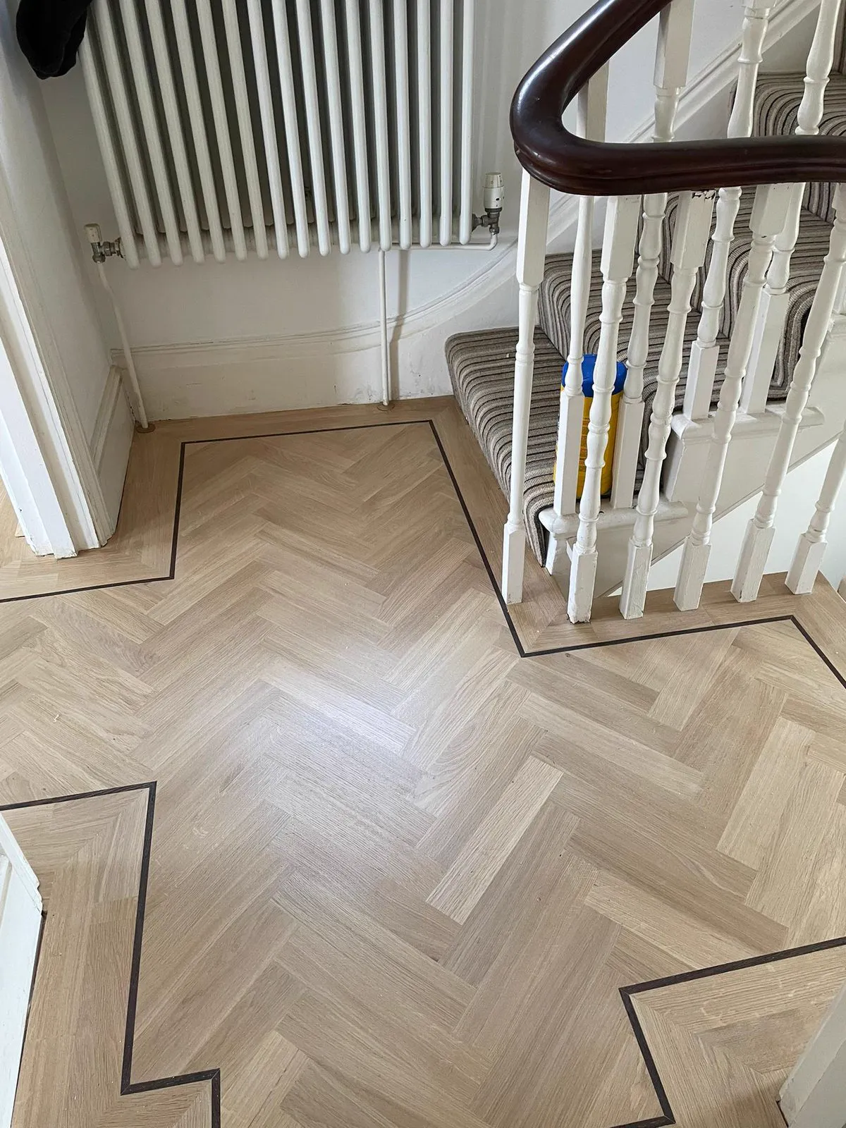 Herringbone parquet hallway with painted stairs in Clapham SW4