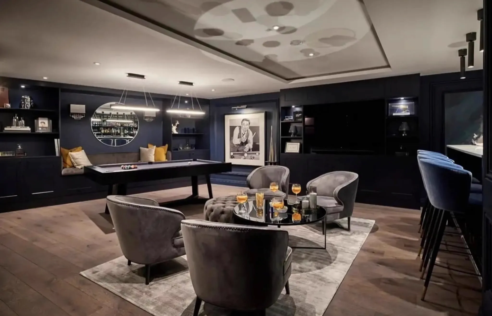 Wide plank oak floor in a dark navy games room with a pool table and bar, laid and finished by Howard Naish